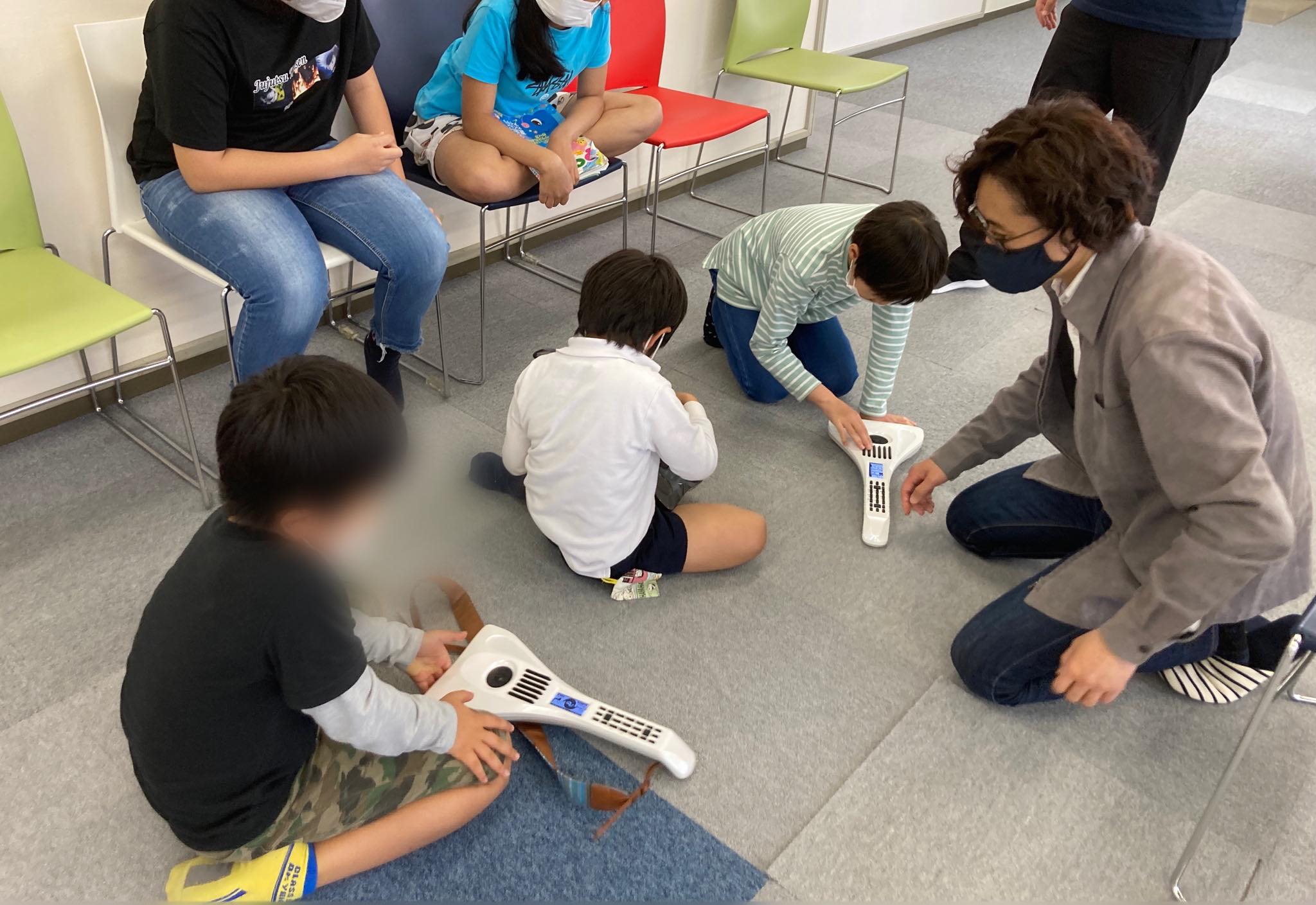 子どもたちが電子楽器を試し、ゆーいちがそばで見守る体験会